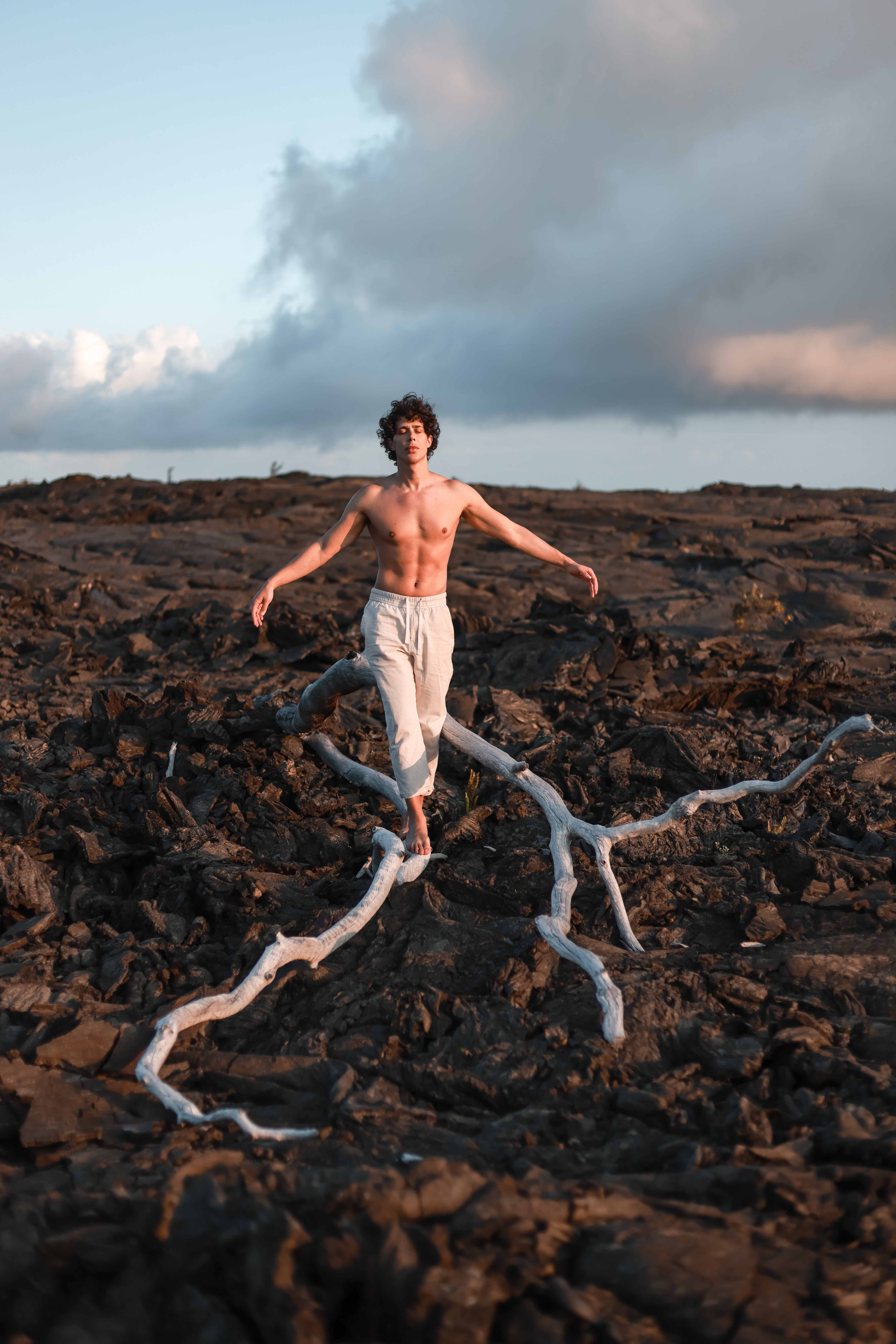 Vulcano Kilauea, nel parco nazionale del vulcano Kilauea a Big Island, Hawaii. In un mare di lava solidificata, un ragazzo danza sopra ad un ramo bianco secco.